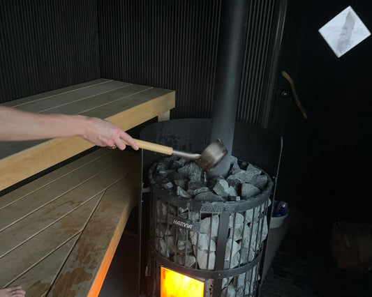 Water being poured onto hot stones in a Finnish sauna, creating löyly.